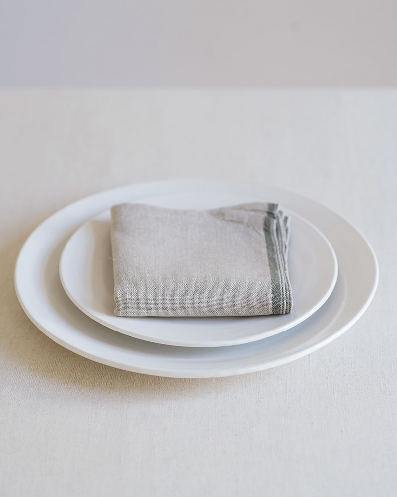 Mungo Natural Flax selvedge napkin with an urbn olive stripe that runs down the true selvedge, woven of our antique looms in plettenberg bay