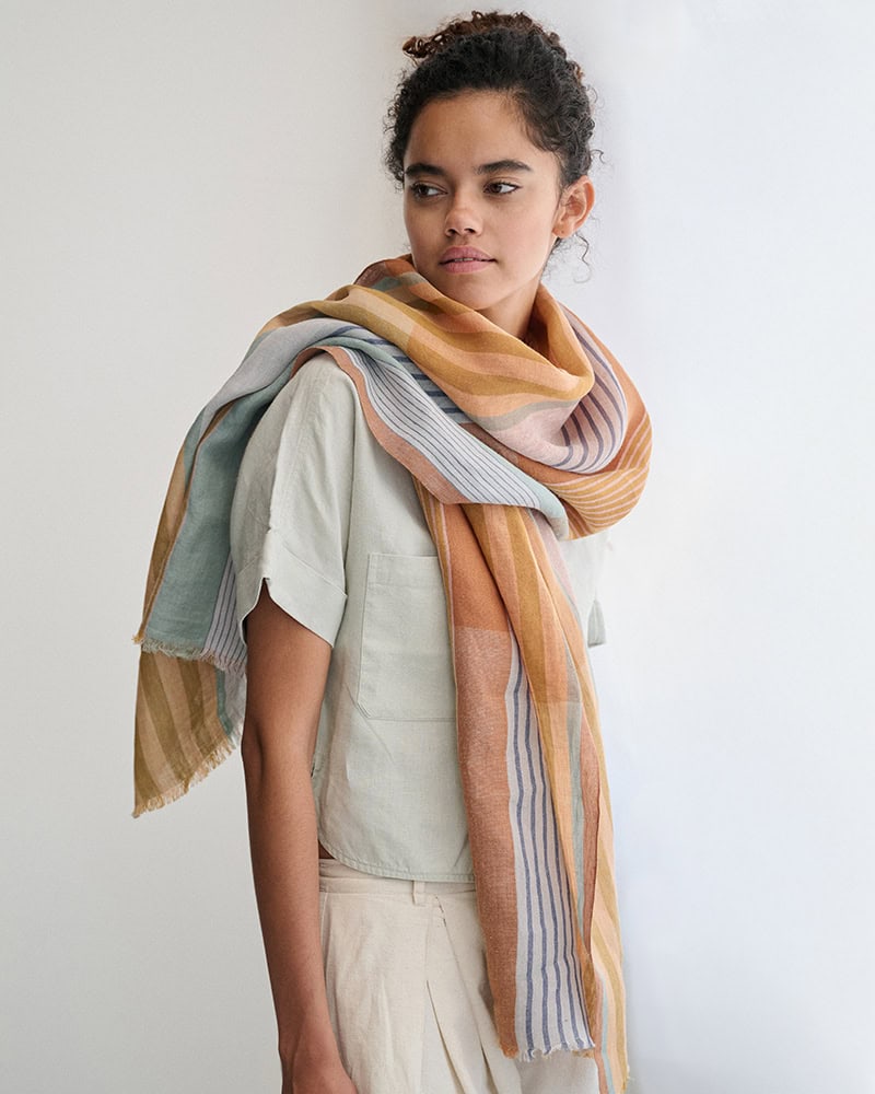 Model standing wearing Mungo Linen scarf in Jewel.
