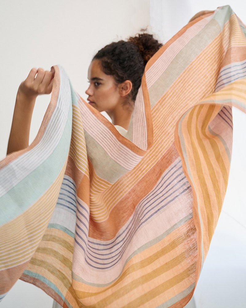 Model opening and waving the 100% Linen scarf in Jewel.