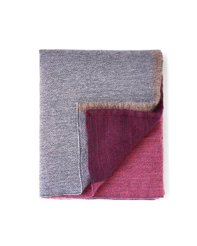 Folded Mungo MOS Shawl in Ladybird. Woven with Bamboo, Mohair and silk and displaying it's maroon, pink and grey tones.